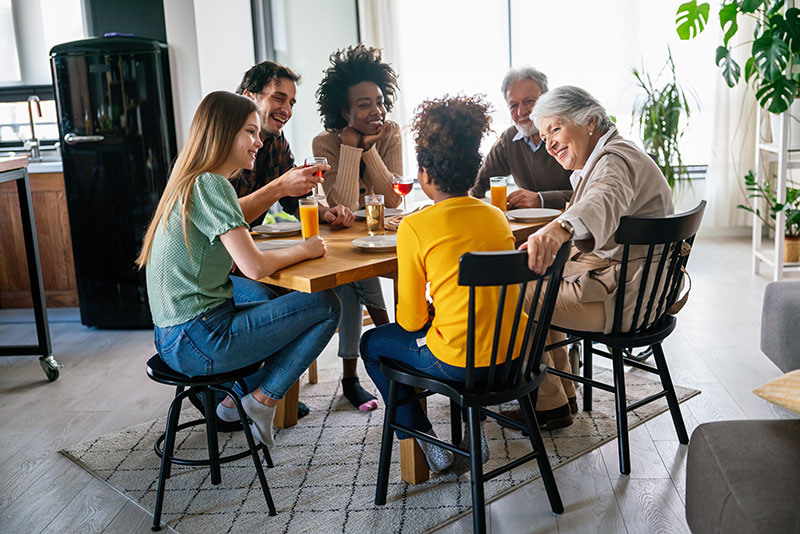 Multigenerational biracial family around dinner table
