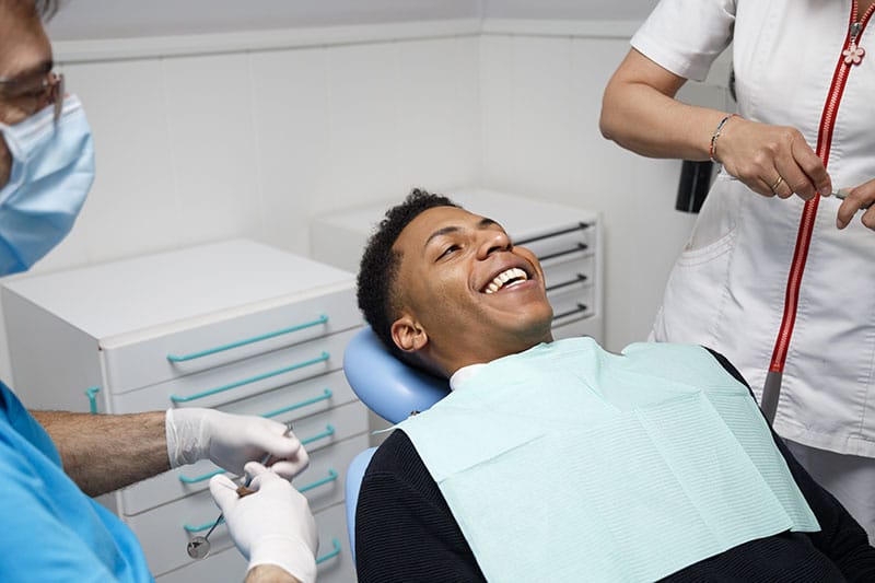 Young man sitting in dentist chair, smiling